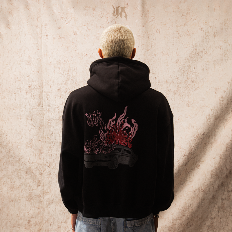 Person wearing a black hoodie with a logo on a white background