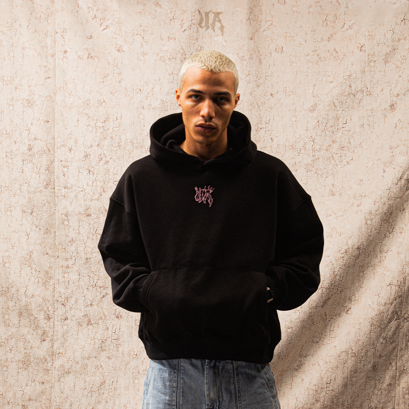 Person wearing a black hoodie with a logo on a white background