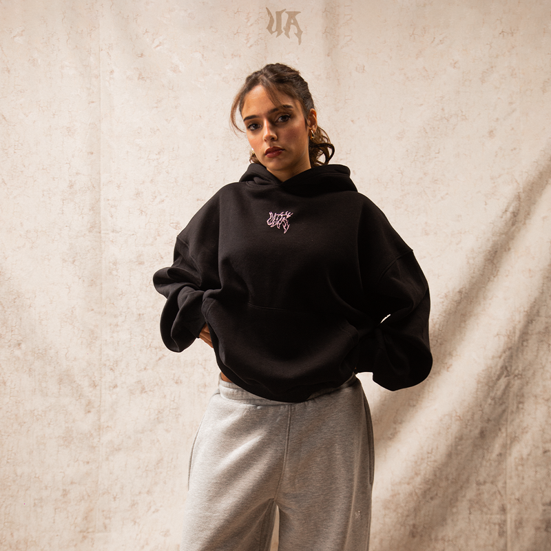 Person wearing a black hoodie with a logo on a white background
