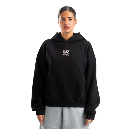 Person wearing a black hoodie with a logo on a white background